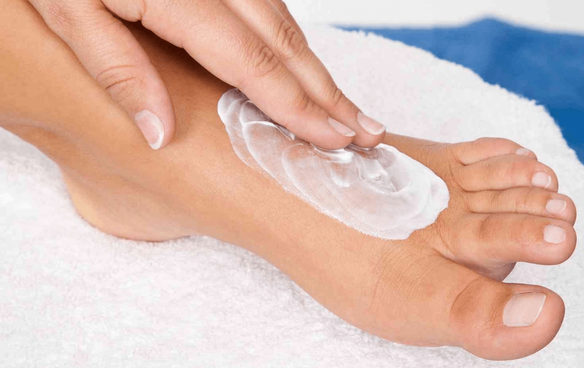 applying an anti-fungal ointment to the feet